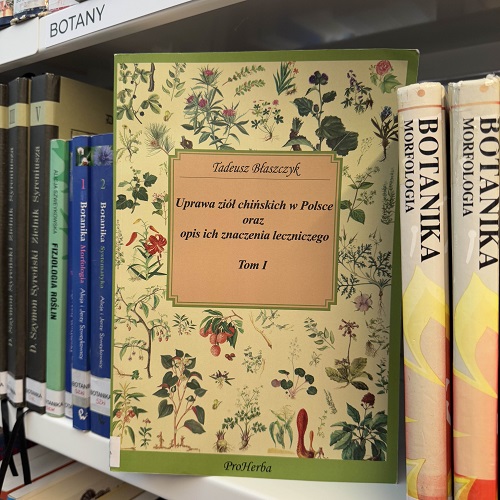 Ustawiona na regale książka "Uprawa ziół chińskich w Polsce oraz opis ich znaczenia leczniczego. Tom 1". Opis znajduje się na dole